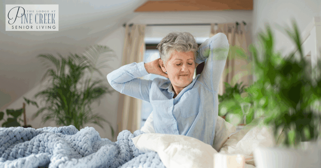 A senior woman with dementia sleep problems is sitting up in bed, stretching in the morning.